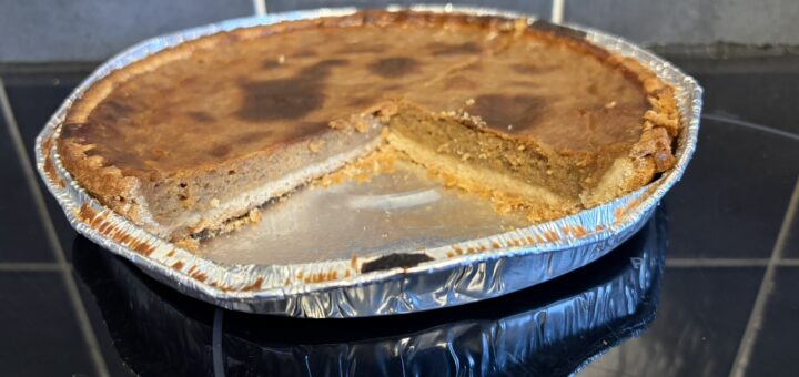 Pumpkin pie with a slice taken out of it